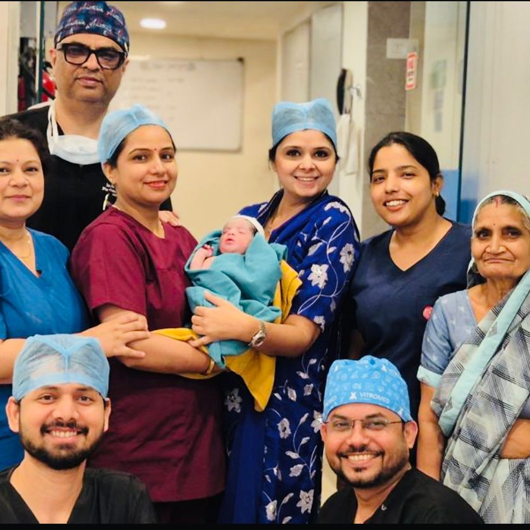 HomeIVF fertility doctors and family celebrating a healthy newborn baby delivery